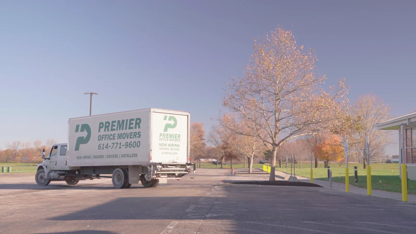 A branded Premier Office Movers truck parked at a Columbus, OH commercial property
